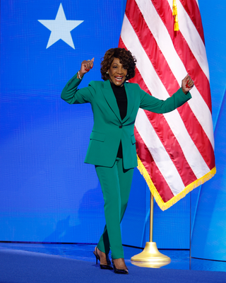 Image may contain Maxine Waters Adult Person Clothing Formal Wear Suit Coat Flag Face and Head